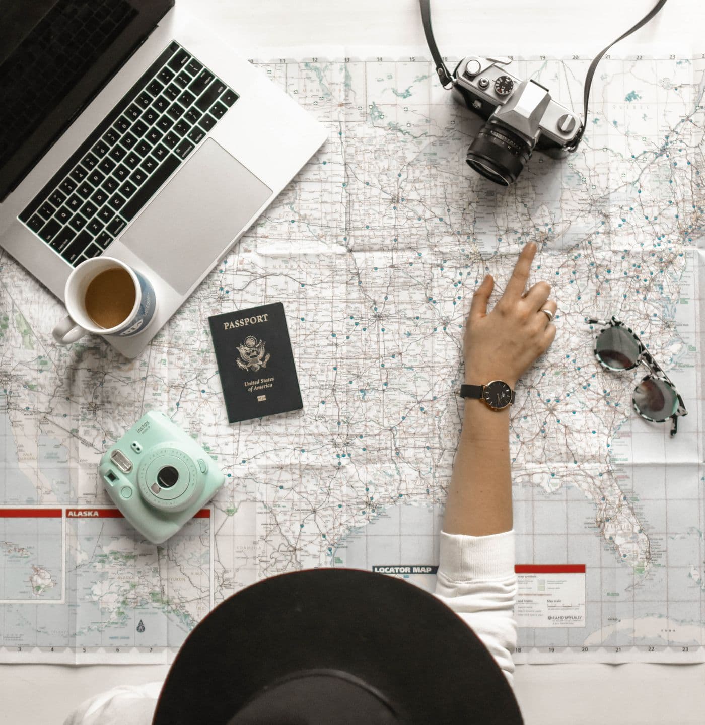 Travel planning with a map, passport and laptop