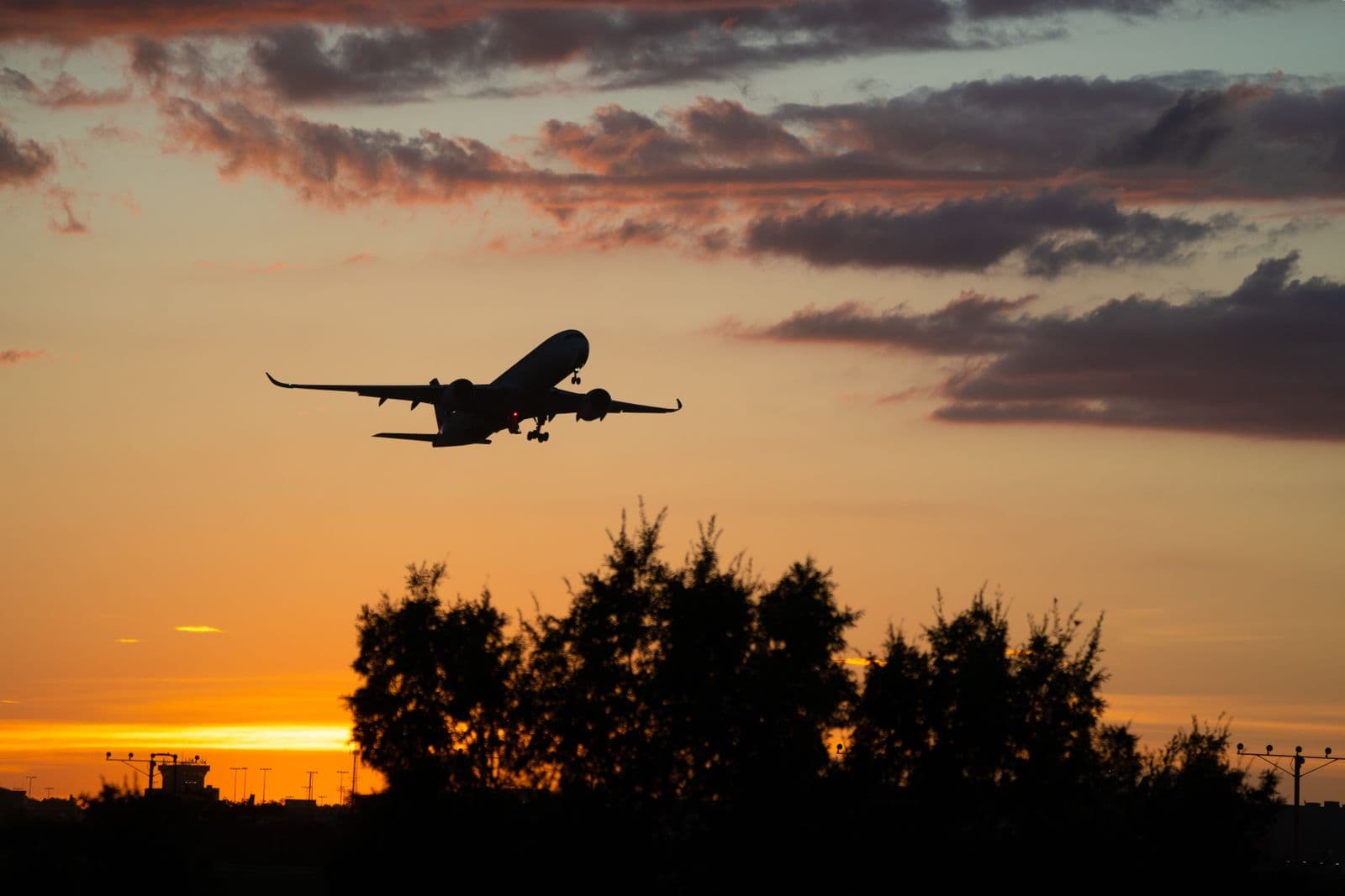 Passenger aircraft silhouetted against a golden sunset